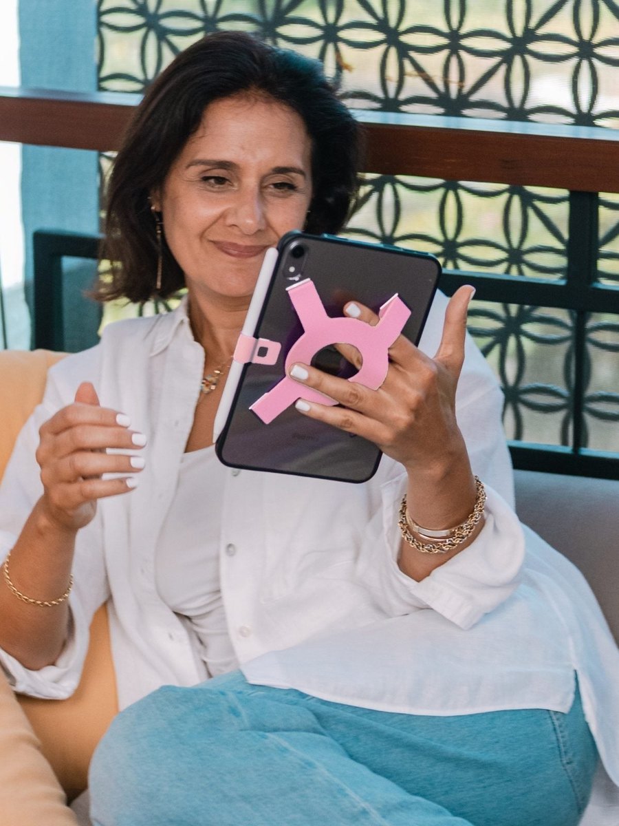Woman smiling at her iPad mini with the Strapsicle case