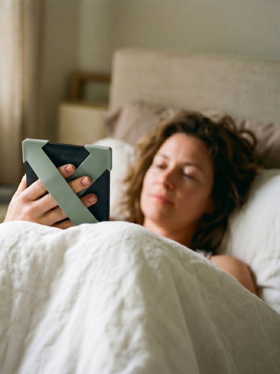 Woman reading in bed with sage green Strapsicle straps