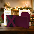 A mulled wine straps and clutch with packaging on a wooden surface with blurred lights in the background