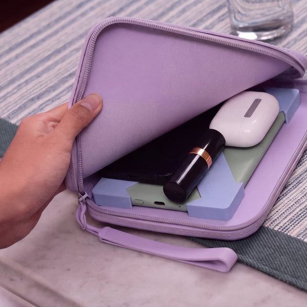 Open lilac Strapsicle clutch holding an e-reader and everyday items