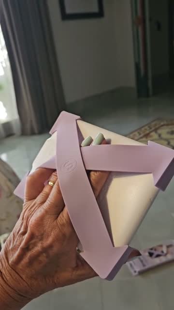 Hand holding a Kindle with lilac Strapsicle straps